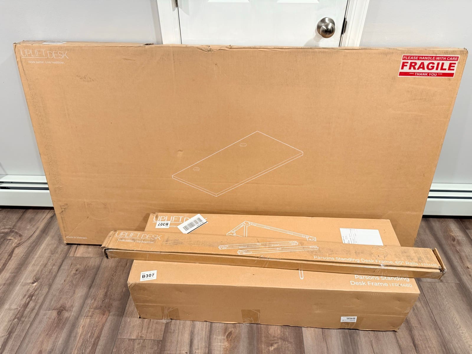 All three UPLIFT Parsons boxes leaning against the door