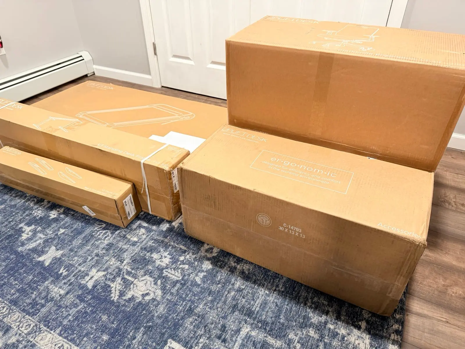 All six UPLIFT Desk boxes stacked in the basement