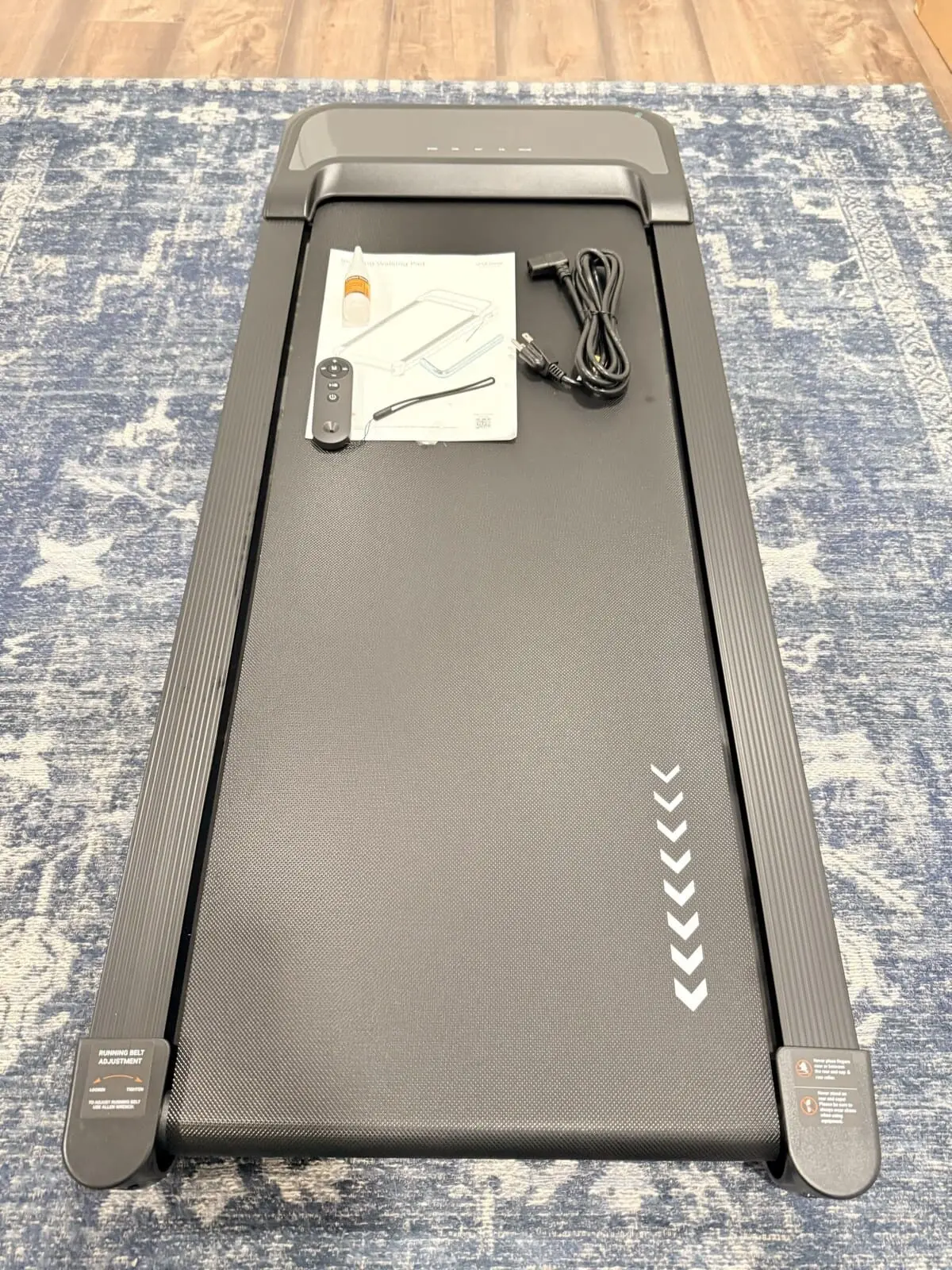 Walking pad laid flat with remote control, lubricant, and manual