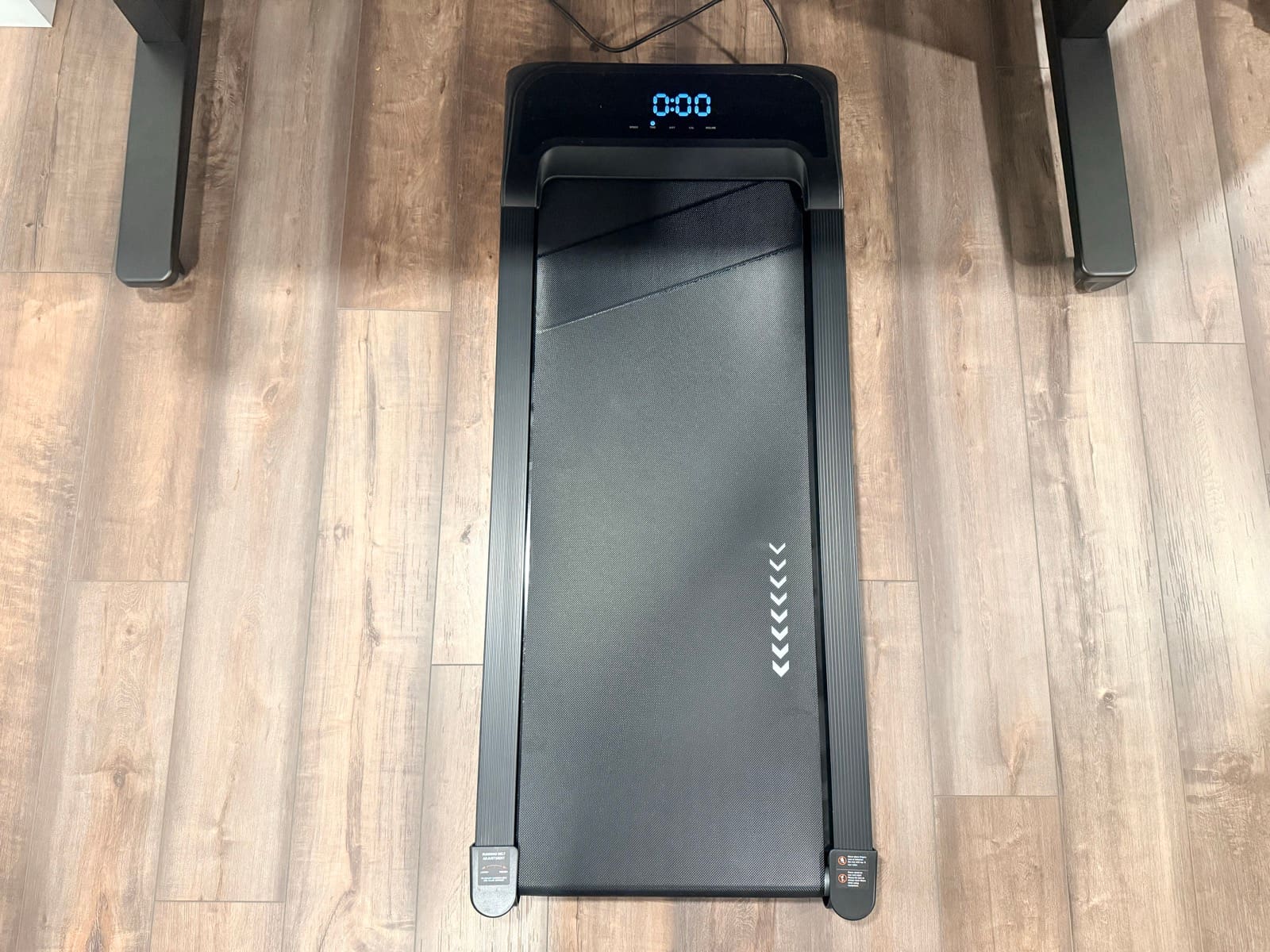 Top-down view of the walking pad between the UPLIFT V3 desk legs