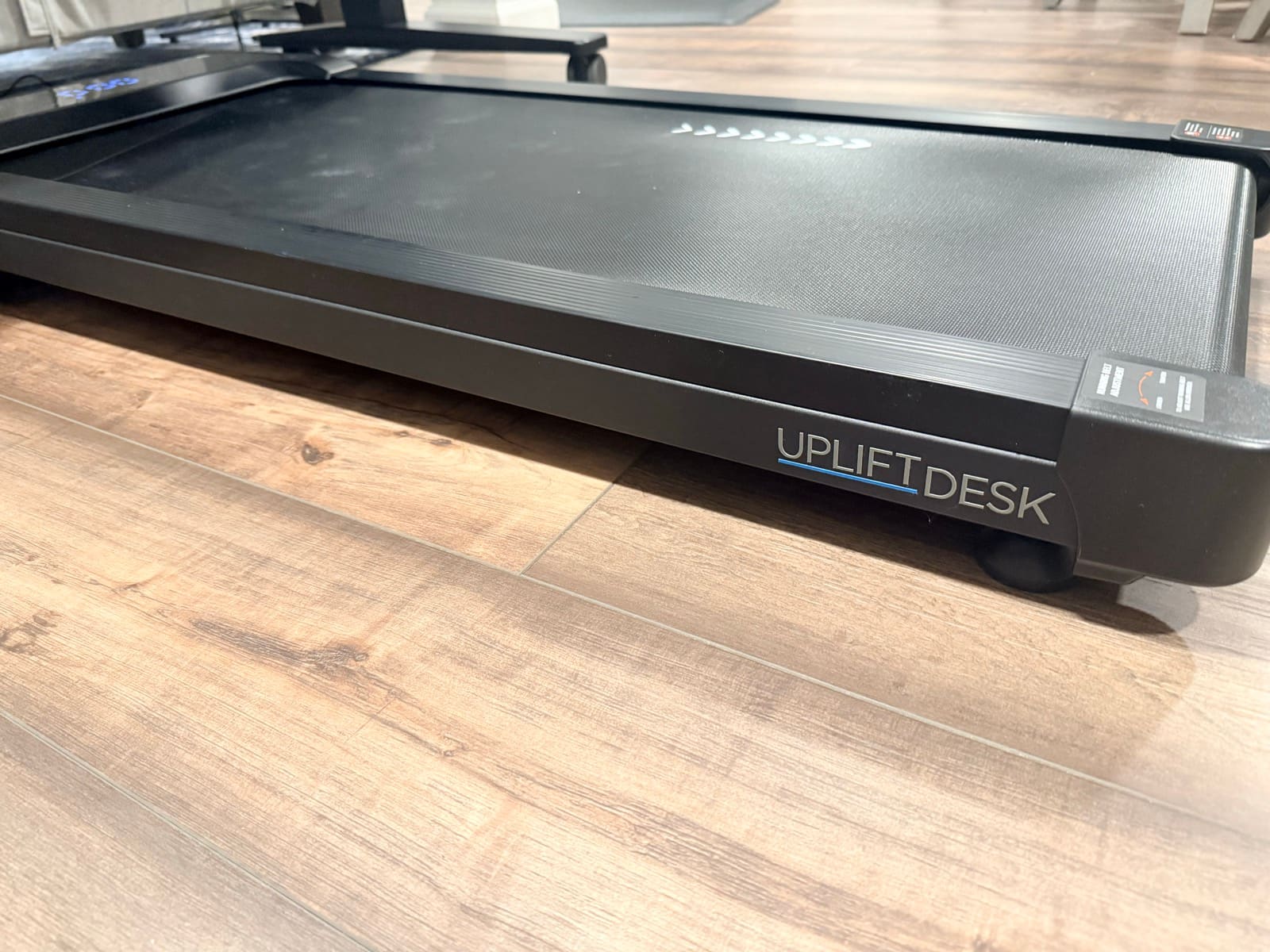 Side angle showing UPLIFT DESK branding and low profile design